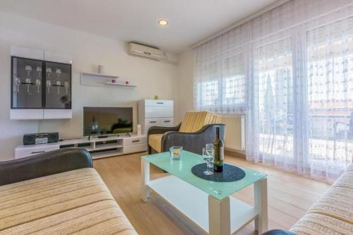 ein Wohnzimmer mit einem Sofa und einem Tisch in der Unterkunft Apartments Cvetkovic in Crikvenica