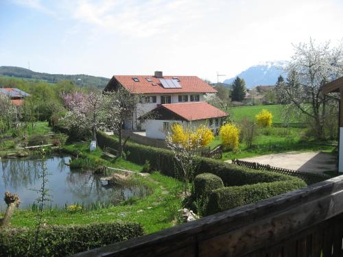 a house with a garden and a pond in a yard at Ferienwohnung Anneliese Eckhart in Anger