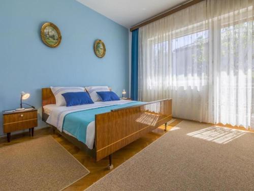 a blue bedroom with a bed and a large window at Apartments Tara in Selce