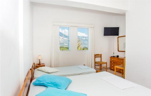 - une chambre avec 2 lits et une fenêtre dans l'établissement Blue White Apartments, à Céphalonie