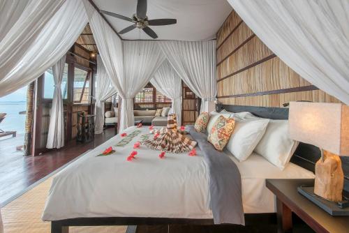 1 dormitorio con 1 cama y ventilador de techo en Papua Paradise Eco Resort en Pulau Birie
