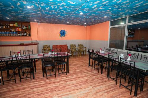 uma sala de jantar com mesas e cadeiras e um bar em Hotel Dela Mount Pokhara em Pokhara