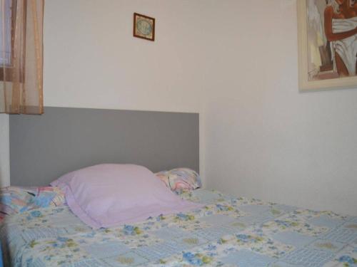 - un lit non aménagé dans une chambre avec une horloge sur le mur dans l'établissement Appartement climatisé avec terrasse dans quartier animé, parking privé - FR-1-225D-573, à Saint Cyprien Plage