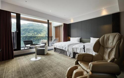 台北市にあるThe Tango Hotel Taipei Jiantanのベッドと大きな窓が備わるホテルルームです。