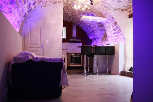 a purple room with a table and a stage at Gite de la Fontaine in Paulhe