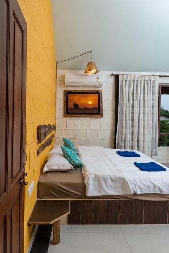 a small bedroom with a bed and a window at Avontade Suites in Anjuna