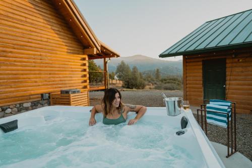 une femme est dans un bain à remous dans une cabine dans l'établissement Yosemite Charm by Casa Oso with spa and breathtaking views, à Mariposa
