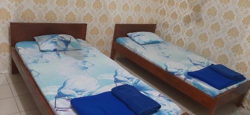 two twin beds sitting next to each other at KARATU HOMESTAY in Poso
