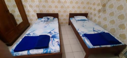 two beds sitting next to each other in a room at KARATU HOMESTAY in Poso