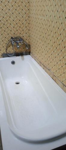 - białą toaletę w łazience ze ścianą wyłożoną kafelkami w obiekcie Greendale apartment and Lodge w mieście Ibadan