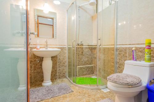 a bathroom with a shower and a toilet and a sink at Art-inspired 3BR Apartment in Nairobi