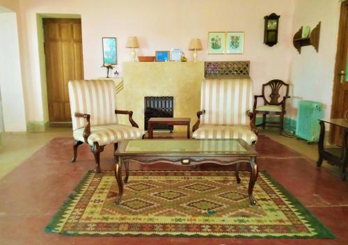 a living room with two chairs and a coffee table at Morgah Resort - Guest Rooms in Rawalpindi