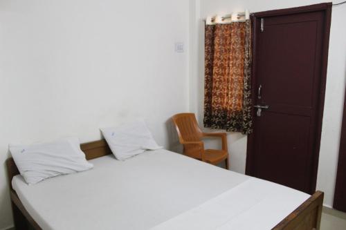 1 dormitorio con cama, puerta y silla en Agp Homestay en Chennai