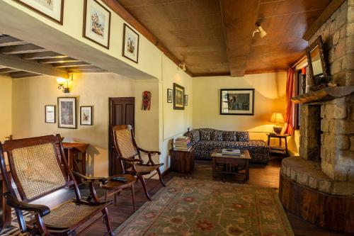 a living room with a couch and a table and chairs at StayVista at Tea House 2BR with fragrant tea gardens in Dharamshala in Dharamshala