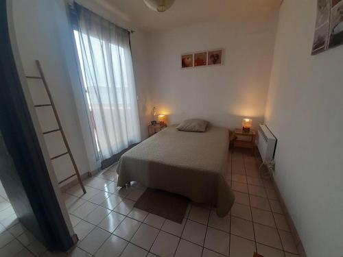- une chambre avec un lit et deux lampes au sol carrelé dans l'établissement T2 Agréable Près de l'Étang de Thau et Thermal, Balcon, Wi-Fi, Lave-Linge, Bien Équipé, Balaruc-les-Bains - FR-1-571-32, à Balaruc-les-Bains