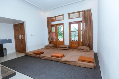 Cama grande en habitación con ventana grande en De Bloem Lake View Pangalengan, en Pengalongan