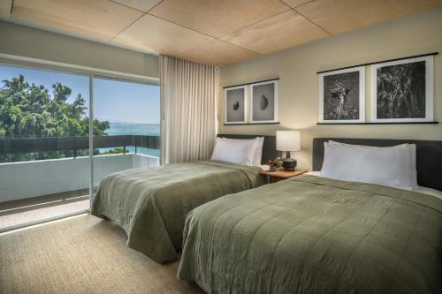 a bedroom with two beds and a large window at PACIFIC 19 Kona in Kailua-Kona