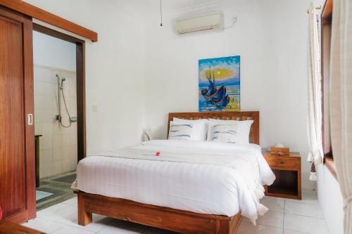 a bedroom with a large bed with white sheets at Villa Bumi Ayu Sanur in Sanur