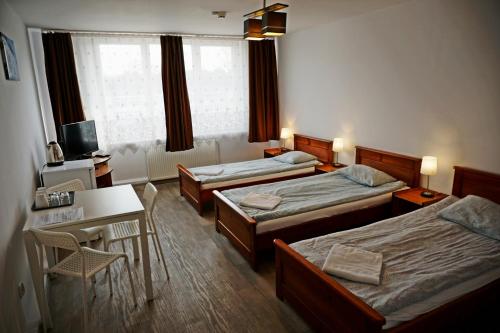 a hotel room with two beds and a desk and a desk at SCSK Brzeźno in Gdańsk