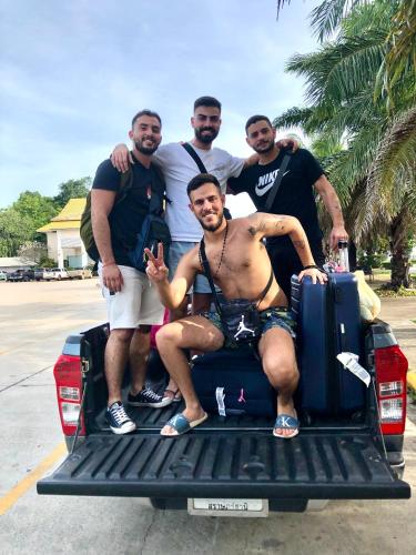 a group of men sitting on the back of a truck at Baansrisuthum in Don Sak