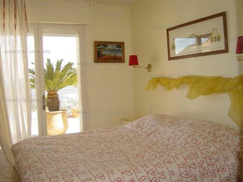 une chambre avec un lit et une porte coulissante en verre dans l'établissement Villa 6 chambres avec piscine chauffée - FR-1-100-252, à Cavalaire-sur-Mer