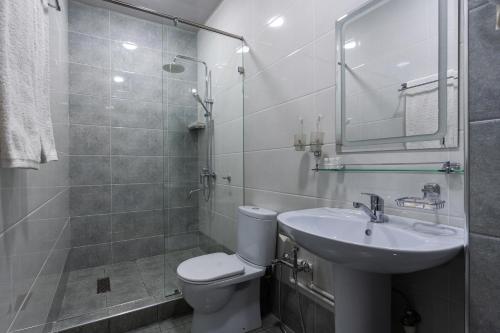 a bathroom with a toilet and a sink and a shower at ABIS Palace Hotel in Tashkent