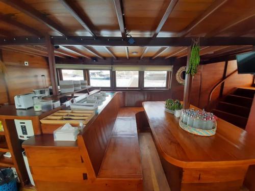 a kitchen with a wooden table in a boat at Komodo Liveaboard 3 Days 2 Night in Labuan Bajo
