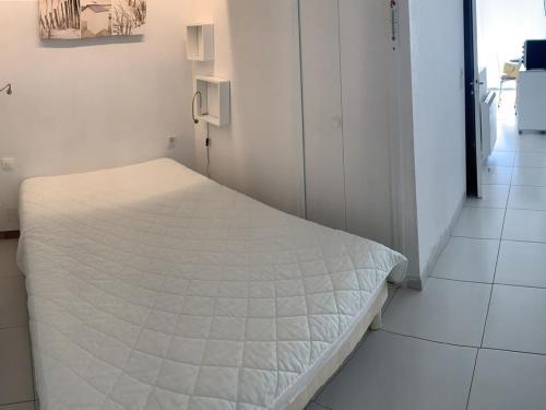 a bedroom with a white bed in a room at T1 Classé 3 Étoiles avec Animaux Admis et Climatisation - FR-1-571-49 in Balaruc-les-Bains