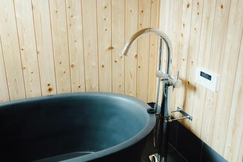 uma banheira azul numa casa de banho com painéis de madeira em Worcation base Kaminyu Yamane House - Vacation STAY 03960v em Nagahama