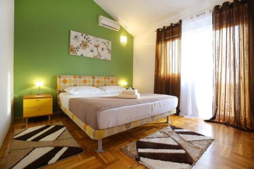 ein Schlafzimmer mit einem Bett und einer grünen Wand in der Unterkunft House Lavanda in Premuda