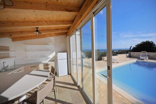 a house with a swimming pool with glass doors at House Lavanda in Premuda