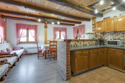 eine Küche mit Holzschränken und ein Wohnzimmer in der Unterkunft Rustic Cottage With Heated Pool - Happy Rentals in Velika Buna