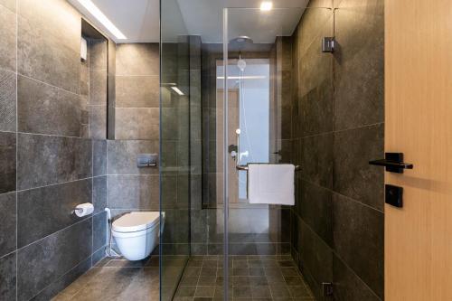 a bathroom with a toilet and a glass shower at Purple Haze By AirCasa in Nairobi