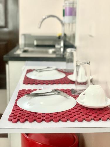 a kitchen counter with two plates and a sink at The Persimmon Studios Near Ayala and SM City Cebu in Cebu City