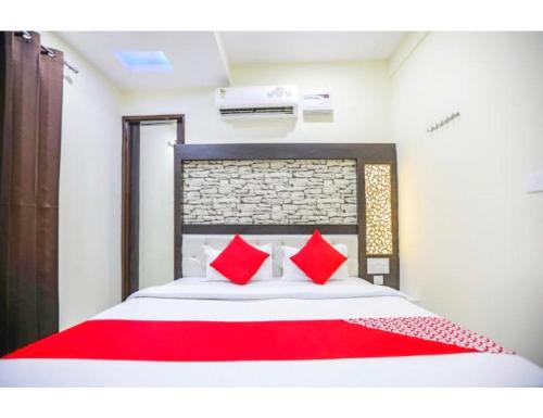 a bedroom with a large bed with red pillows at Hotel Mrg Inn, Sri Ganganagar in Gangānagar