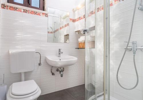 La salle de bains est pourvue de toilettes, d'un lavabo et d'une douche. dans l'établissement Villa Vita, à Trogir