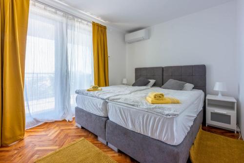 a bedroom with a large bed with yellow curtains at Villa Turquoise breeze in Klenovica