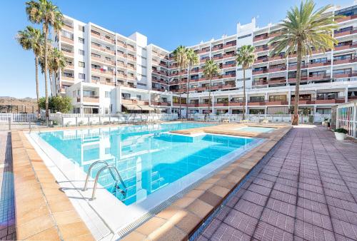 a swimming pool in front of a large apartment building at APARTAMENTO a PIE del MAR in Playa del Ingles
