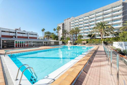 a large swimming pool in front of a large building at APARTAMENTO a PIE del MAR in Playa del Ingles