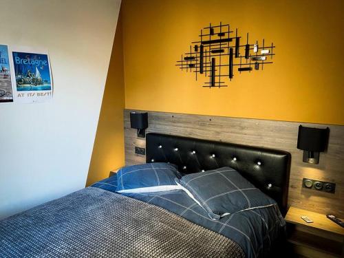 サン・マロにあるApt RDC avec sa terrasse privéeのベッドルーム1室(ベッド1台付)、シャンデリア付きの壁