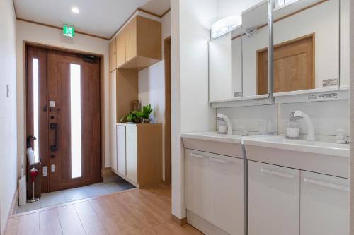 uma cozinha com armários brancos e um lavatório em Y's沖縄リゾートベースNo.1 em Onna