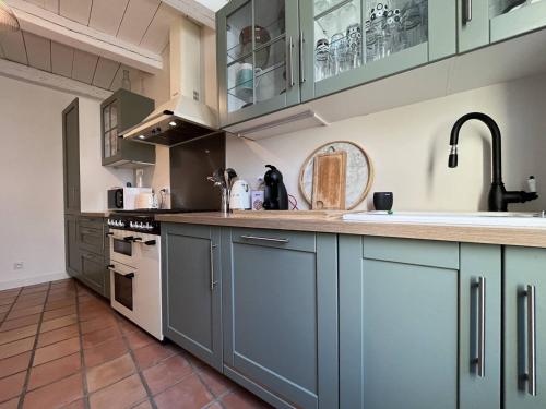 une cuisine avec des armoires bleues et un comptoir dans l'établissement Maison 4 pièces, 6 couchages, centre Saint-Denis d'Oléron, calme, proche plage, WiFi inclus - FR-1-246A-164, à Saint-Denis-dʼOléron