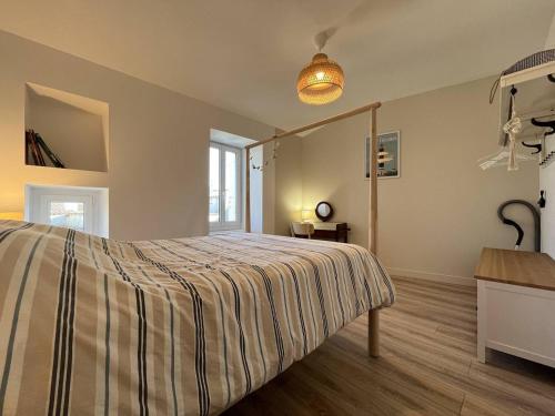 a bedroom with a bed with a striped bedspread at Maison 4 pièces, 6 couchages, centre Saint-Denis d'Oléron, calme, proche plage, WiFi inclus - FR-1-246A-164 in Saint-Denis-dʼOléron
