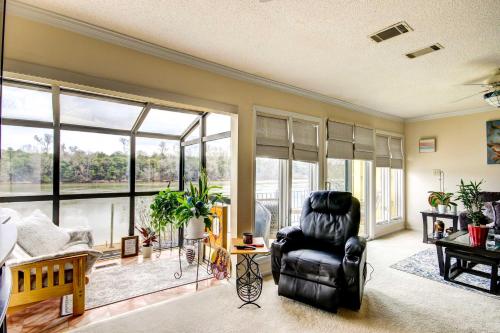 a living room with a chair and large windows at Waterfront Vacation Rental on Savannah River! in Augusta