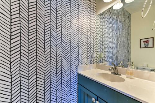ein Badezimmer mit einem Waschbecken und einer blau-weißen Wand in der Unterkunft Lakefront Lexington House with Spacious Deck! in Lexington