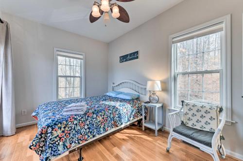 a bedroom with a bed and a chair and windows at Lakefront Lexington House with Spacious Deck! in Lexington