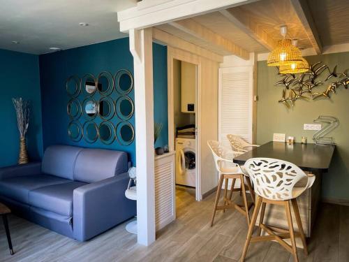 un salon avec un canapé bleu et une table dans l'établissement Appartement Duplex refait à neuf, à Saint-Malo