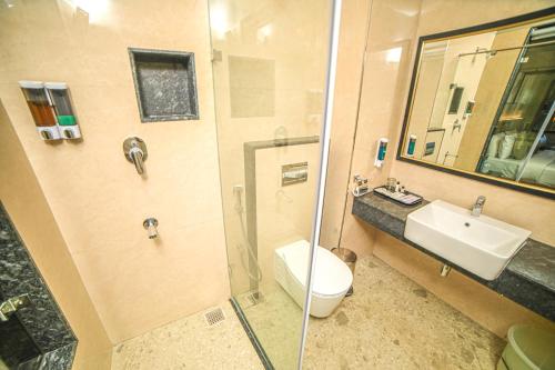 a bathroom with a toilet and a sink and a shower at Grand Palace Hotel & Spa in Yercaud