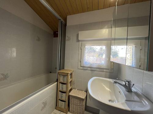 ein Badezimmer mit einem Waschbecken und einer Badewanne in der Unterkunft Maison Saint-Denis-d'Oléron, 4 pièces, 6 personnes - FR-1-246A-196 in Saint-Denis-dʼOléron