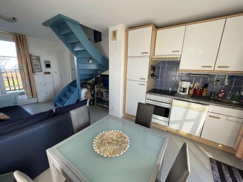 un salon avec une table en verre et une cuisine dans l'établissement Duplex à Wimereux avec Balcon, Parking et Wi-Fi - FR-1-675-16, à Wimereux